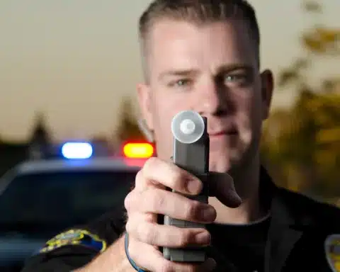 Policeman Holding Breathalyzer - Toronto Police Enforce Mandatory Breathalyzer Tests