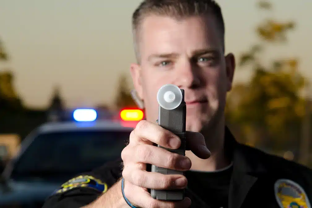 Policeman Holding Breathalyzer - Toronto Police Enforce Mandatory Breathalyzer Tests