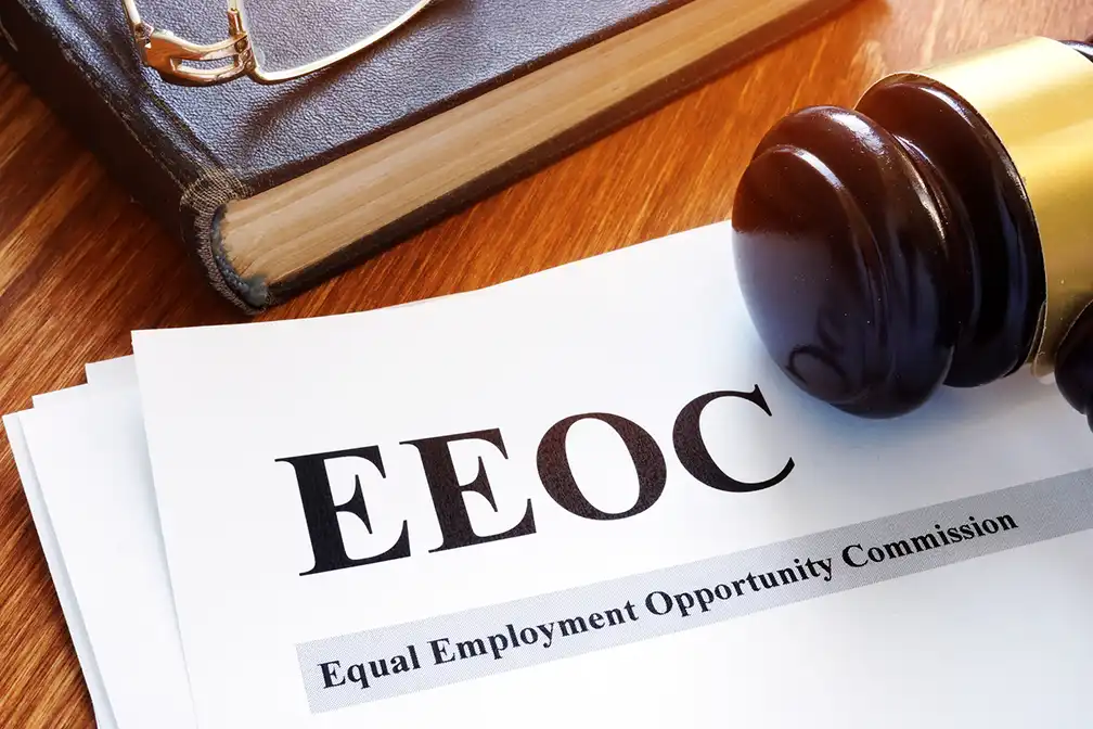 Gavel resting on EEOC paperwork labeled Equal Employment Opportunity Commission on a wooden desk.